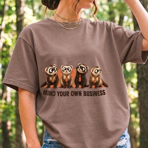 Four ferrets in tiny ties in a row with the text "Mind Your Own Business"