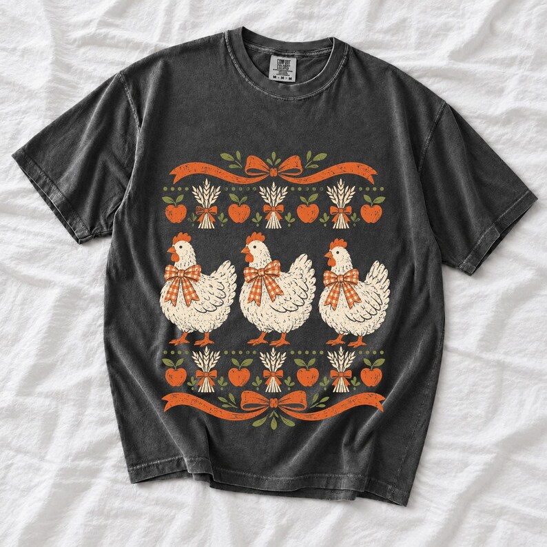 Three fluffy hens with gingham bows between apple and wheat borders, retro folk art fall t-shirt design