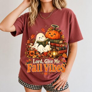 Smiling pumpkin with a halo beside a stack of books and a lantern, text "Lord, Give Me Fall Vibes", retro fall illustration