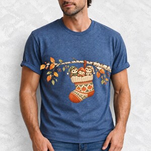 Three watercolor owlets in pajamas and nightcaps tucked into a knitted stocking on a birch branch, one asleep