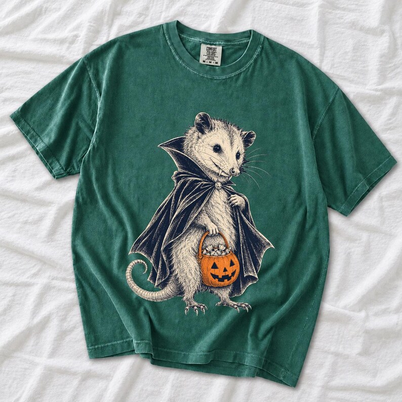 Etched pen illustration of an opossum in a vampire cape holding a candy pumpkin, bone white with orange accent