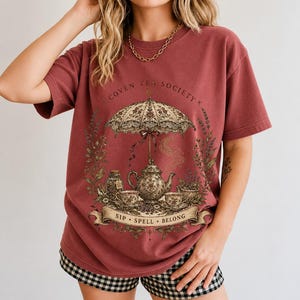 Vintage poster style ornate teapot with crescent moon steam, teacups and herbs, text Coven Tea Society