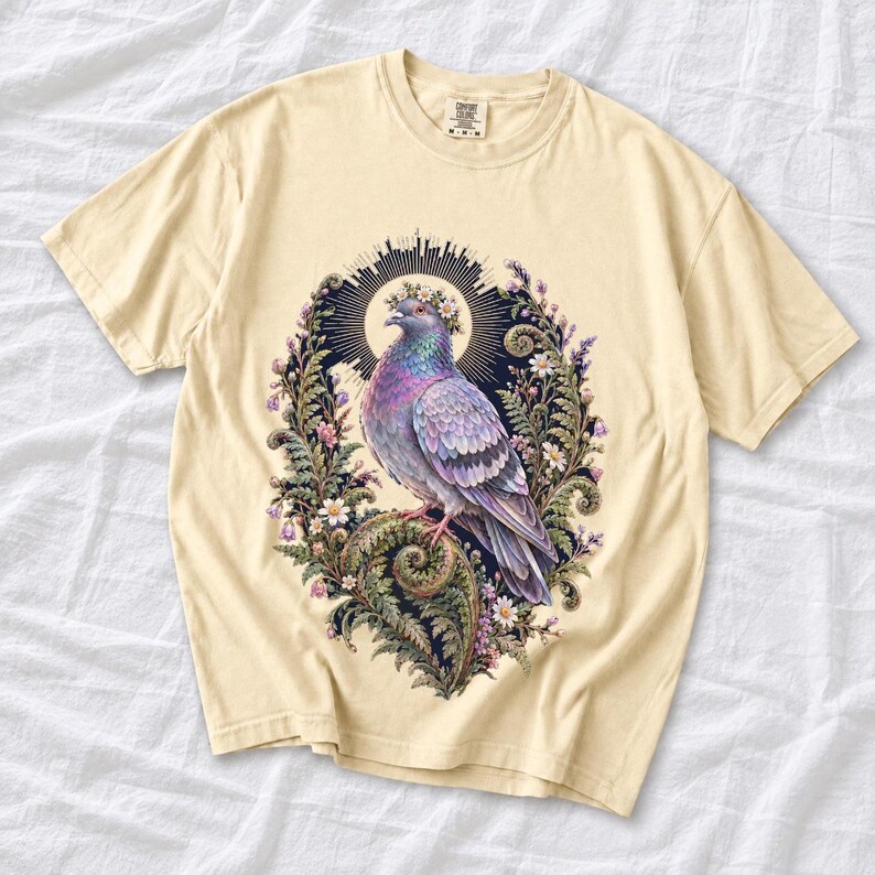 Painted pigeon wearing a daisy crown and glowing halo standing on a fern frond, whimsical cottagecore bird t-shirt art