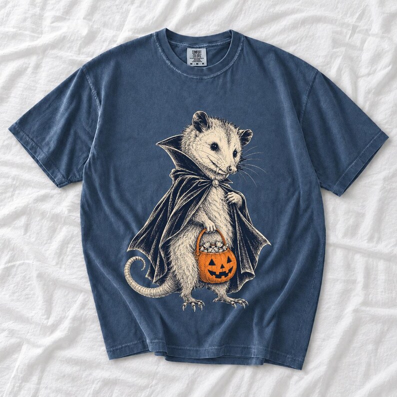 Etched pen illustration of an opossum in a vampire cape holding a candy pumpkin, bone white with orange accent