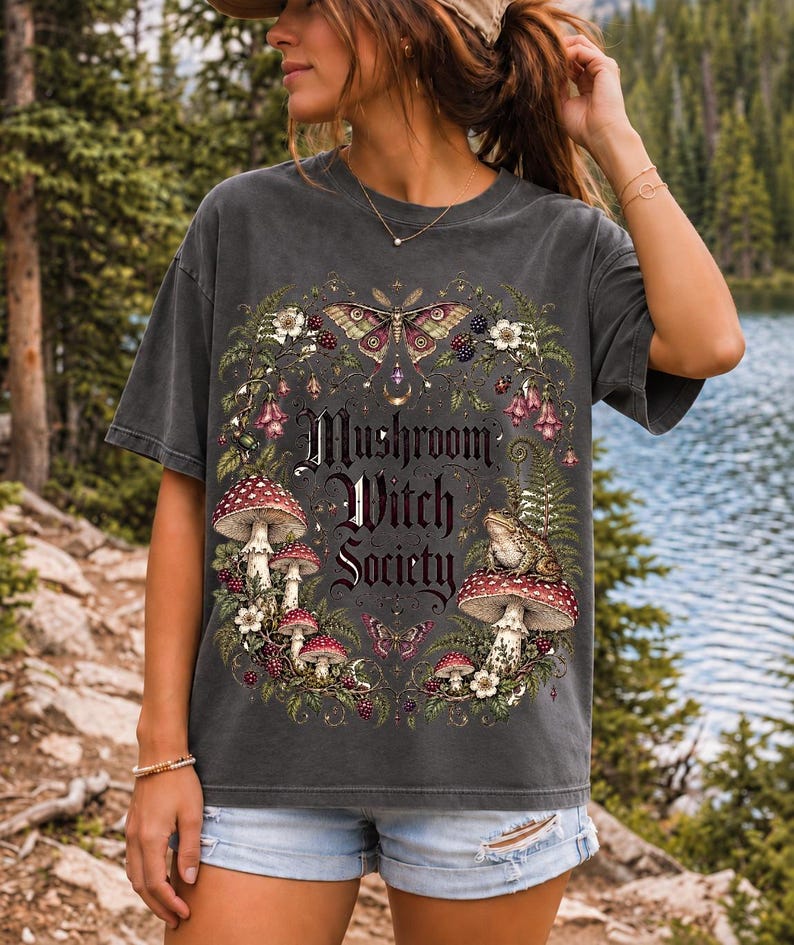 Blackletter text "Mushroom Witch Society" framed by fly agaric mushrooms, ferns and a toad on a mushroom cap