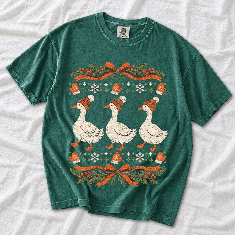 Three geese in pompom knit beanies with mittens, snowflakes and pine borders, retro winter t-shirt graphic