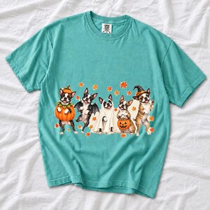Five watercolor Boston terriers in Halloween costumes with falling autumn leaves
