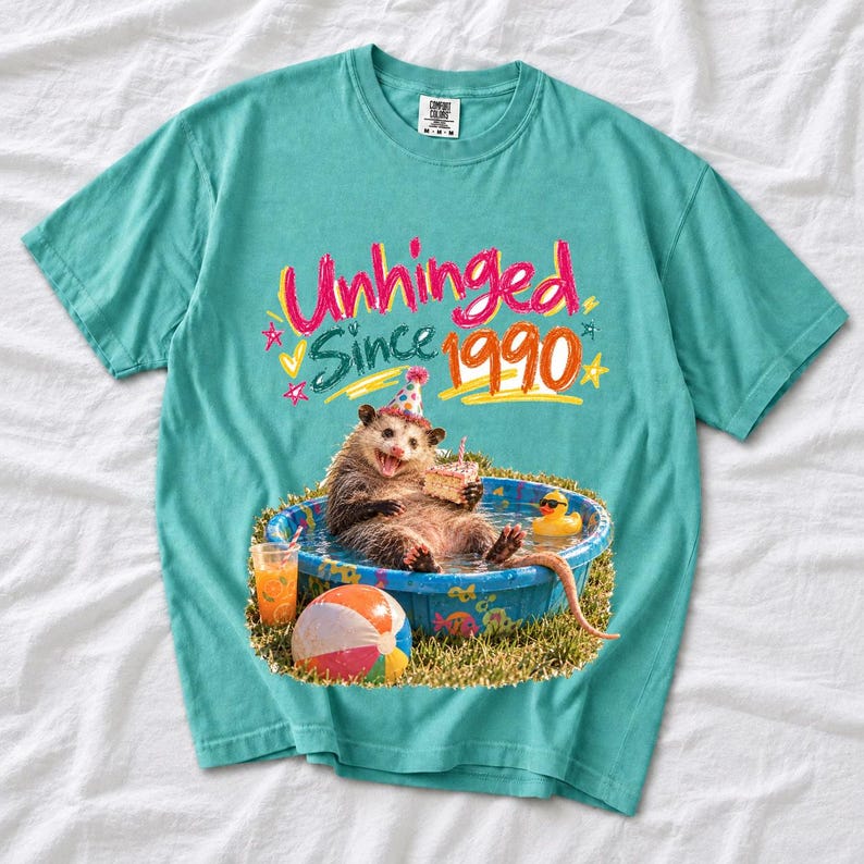 Opossum in party hat in a kiddie pool with cake, 90s film photo style, text "Unhinged Since 1990"
