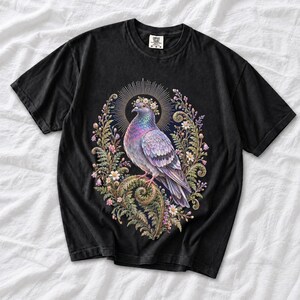 Painted pigeon wearing a daisy crown and glowing halo standing on a fern frond, whimsical cottagecore bird t-shirt art