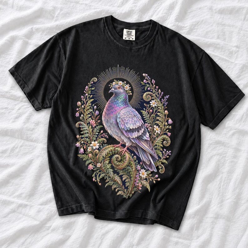 Painted pigeon wearing a daisy crown and glowing halo standing on a fern frond, whimsical cottagecore bird t-shirt art