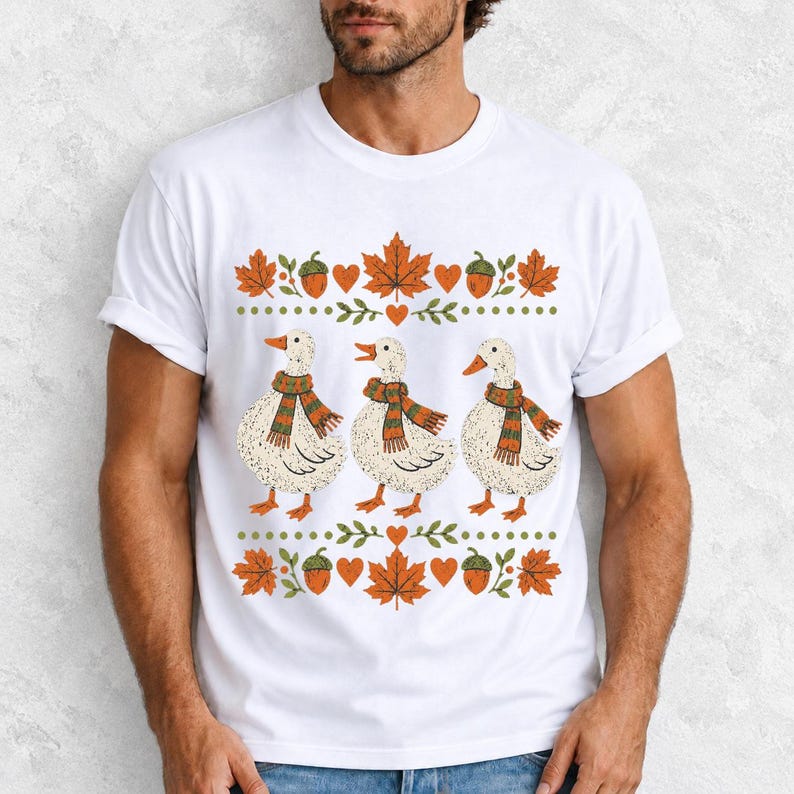 Three white ducks in striped scarves with acorn and maple leaf borders, retro screen print fall t-shirt art