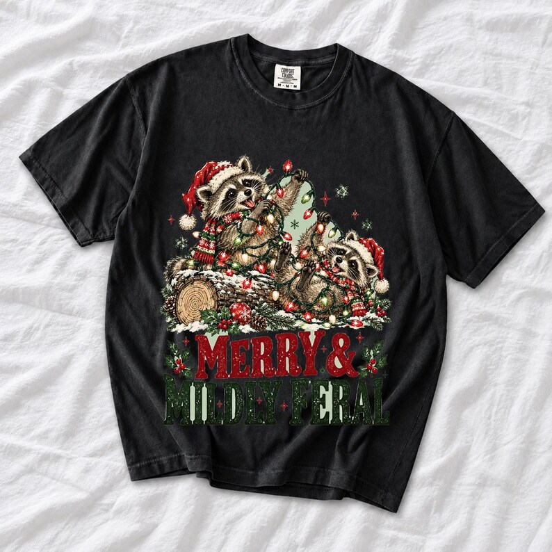 Two raccoons tangled in Christmas lights beside a log with the text Merry & Mildly Feral