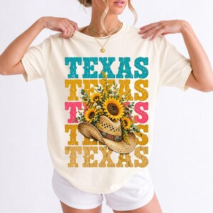 Straw cowboy hat full of sunflowers over a five-line stacked TEXAS word in retro western colors