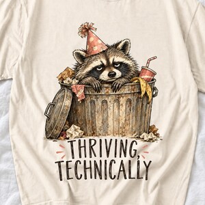 Raccoon in a paper party hat peeking out of a trash can with the text "Thriving, Technically", sepia watercolor sketch