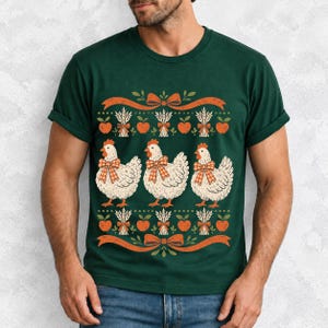 Three fluffy hens with gingham bows between apple and wheat borders, retro folk art fall t-shirt design