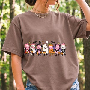 Seven cute erasers with faces in Halloween costumes holding candy buckets, flat crayon colors