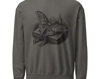 May include: A charcoal gray crewneck sweatshirt featuring a dark graphic print on the chest. The illustration depicts a large moth resting on top of a closed book, positioned next to a single lit candle with a visible flame and dripping wax.