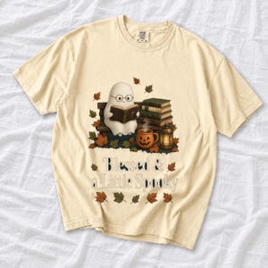 Cute ghost with glasses reading a Bible with a candle and mug, text "Blessed & a Little Spooky", retro fall illustration
