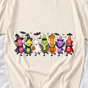 Seven neon highlighter markers with faces in witch, ghost, pumpkin and vampire costumes under bats and stars