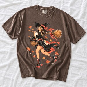Retro 1950s pin-up witch on roller skates with a broom and a cat in a basket, autumn leaves