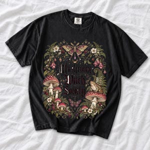 Blackletter text "Mushroom Witch Society" framed by fly agaric mushrooms, ferns and a toad on a mushroom cap