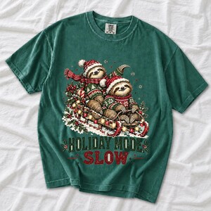 Two sloths in ugly sweaters riding a sled with lights and the text Holiday Mode: Slow