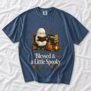 Cute ghost with glasses reading a Bible with a candle and mug, text "Blessed & a Little Spooky", retro fall illustration