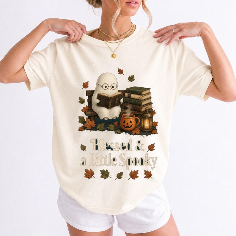 Cute ghost with glasses reading a Bible with a candle and mug, text "Blessed & a Little Spooky", retro fall illustration