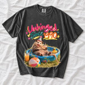 Opossum in party hat in a kiddie pool with cake, 90s film photo style, text "Unhinged Since 1990"