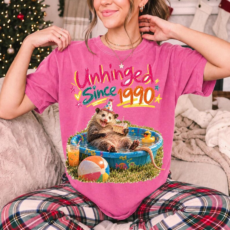 Opossum in party hat in a kiddie pool with cake, 90s film photo style, text "Unhinged Since 1990"
