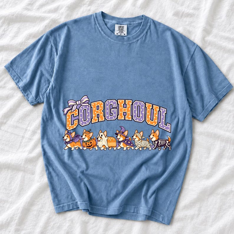 Six corgis in Halloween costumes walking under the arched word CORGHOUL, lavender and orange polka-dot varsity style