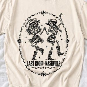 Two cowgirl skeletons in hats line dancing in a starry frame with the text Last Rodeo Nashville
