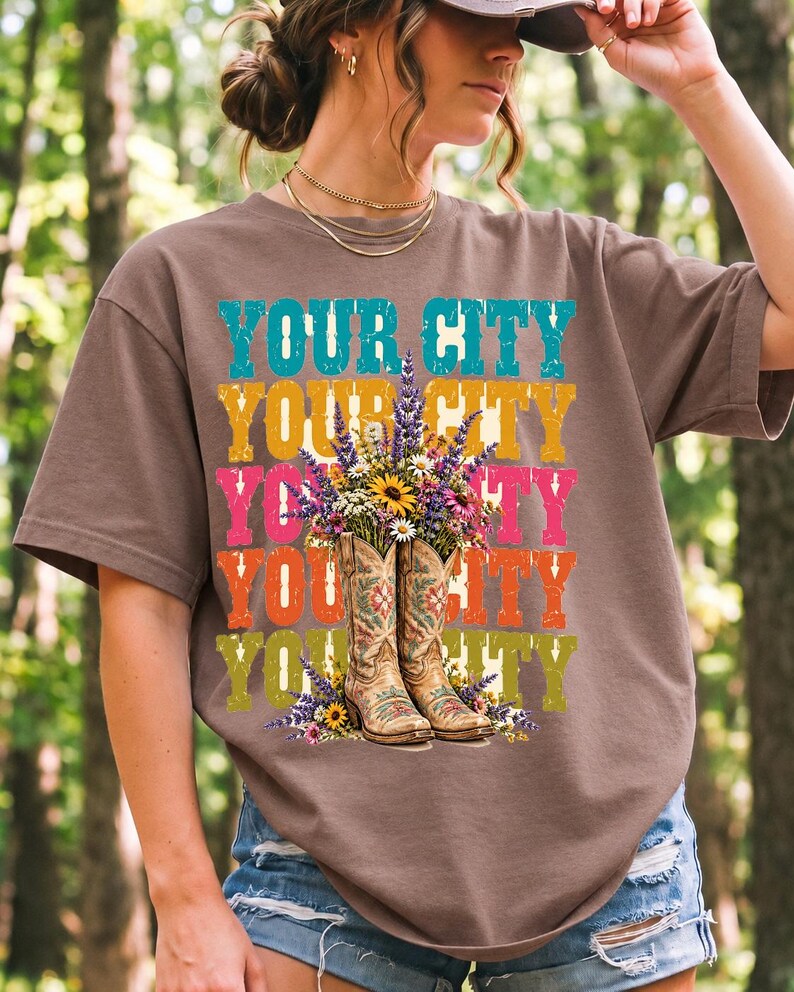 Tan cowboy boots with lavender and wildflowers over a five-line stacked personalized city word in retro colors