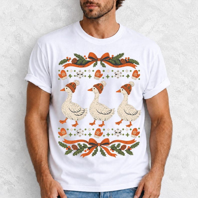 Three geese in pompom knit beanies with mittens, snowflakes and pine borders, retro winter t-shirt graphic