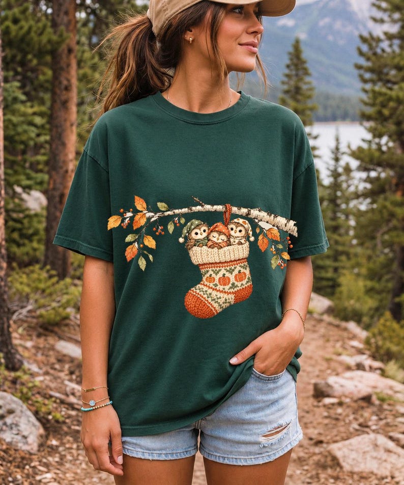 Three watercolor owlets in pajamas and nightcaps tucked into a knitted stocking on a birch branch, one asleep