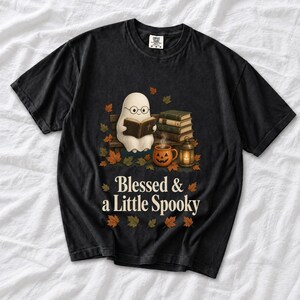 Cute ghost with glasses reading a Bible with a candle and mug, text "Blessed & a Little Spooky", retro fall illustration