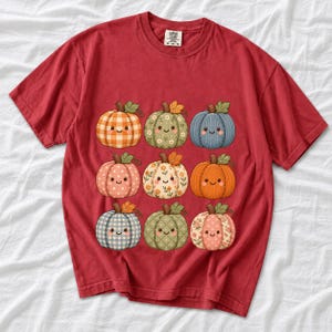 Grid of smiling pumpkins sewn from gingham, floral and corduroy patchwork fabric in autumn colors