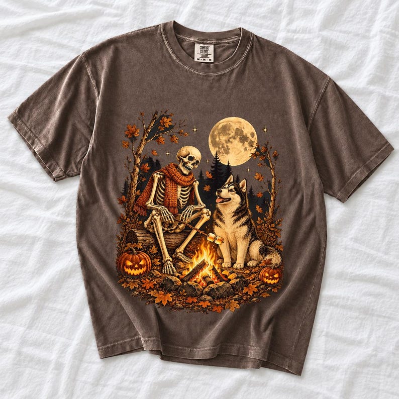 A skeleton in a scarf roasting marshmallows by a campfire beside a husky in an autumn forest under a full moon