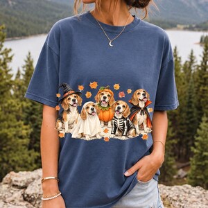 Five watercolor beagles in witch, ghost, pumpkin, skeleton and vampire costumes with floating autumn leaves