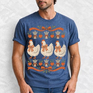 Three fluffy hens with gingham bows between apple and wheat borders, retro folk art fall t-shirt design