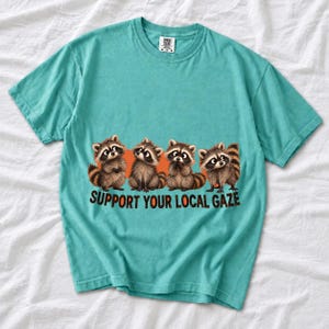Four raccoons in a row with the text "Support Your Local Gaze"