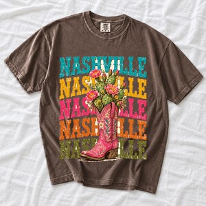 Pink embroidered cowboy boot with blooming cactus over a five-line stacked NASHVILLE word in retro colors