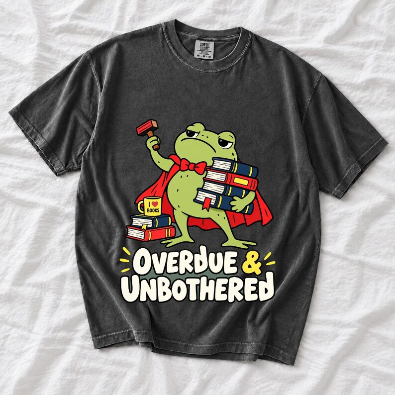 Grumpy cartoon frog librarian holding a stamp and a stack of books with the text Overdue & Unbothered