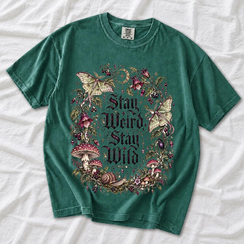 Victorian-style wreath of nightshade, luna moths and toadstools around the words "Stay Weird, Stay Wild"