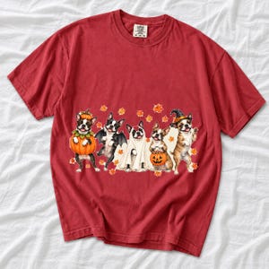 Five watercolor Boston terriers in Halloween costumes with falling autumn leaves