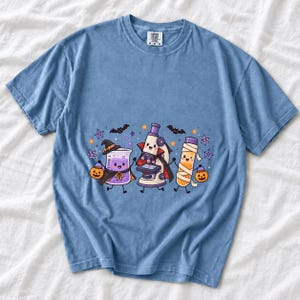 Kawaii beaker, microscope and test tube with faces in Halloween costumes, pastel purple and orange
