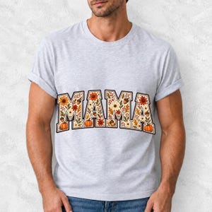 Arched varsity word MAMA filled with fall flowers and acorns in cream, rust and mustard