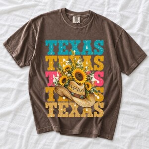 Straw cowboy hat full of sunflowers over a five-line stacked TEXAS word in retro western colors