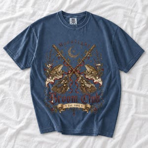 Vintage poster style crossed broomsticks with ribbons, lace and toads, text Moonlight Broom Club Est. 1692
