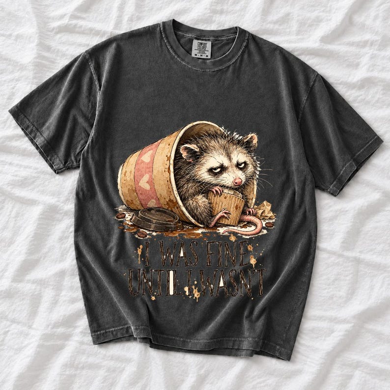 Tired opossum inside a tipped paper coffee cup with the text "I Was Fine Until I Wasn't", sepia watercolor sketch